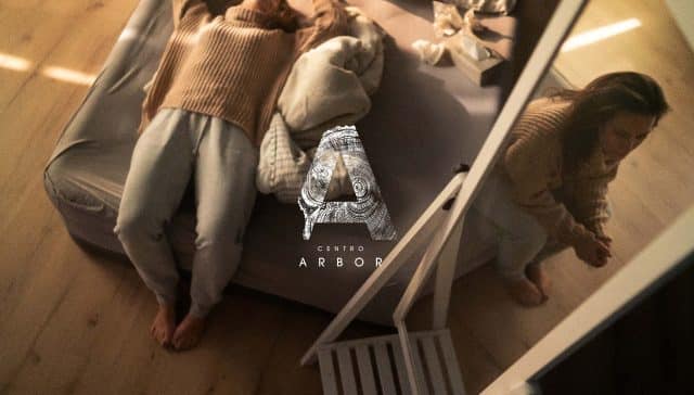 Mujer joven con trastorno límite de la personalidad tumbada en la cama y reflejada en un espejo