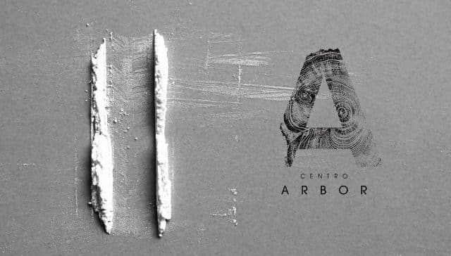 Dos líneas de polvo blanco simulando cafeína esnifada junto al logotipo de Centro Árbor sobre fondo gris.