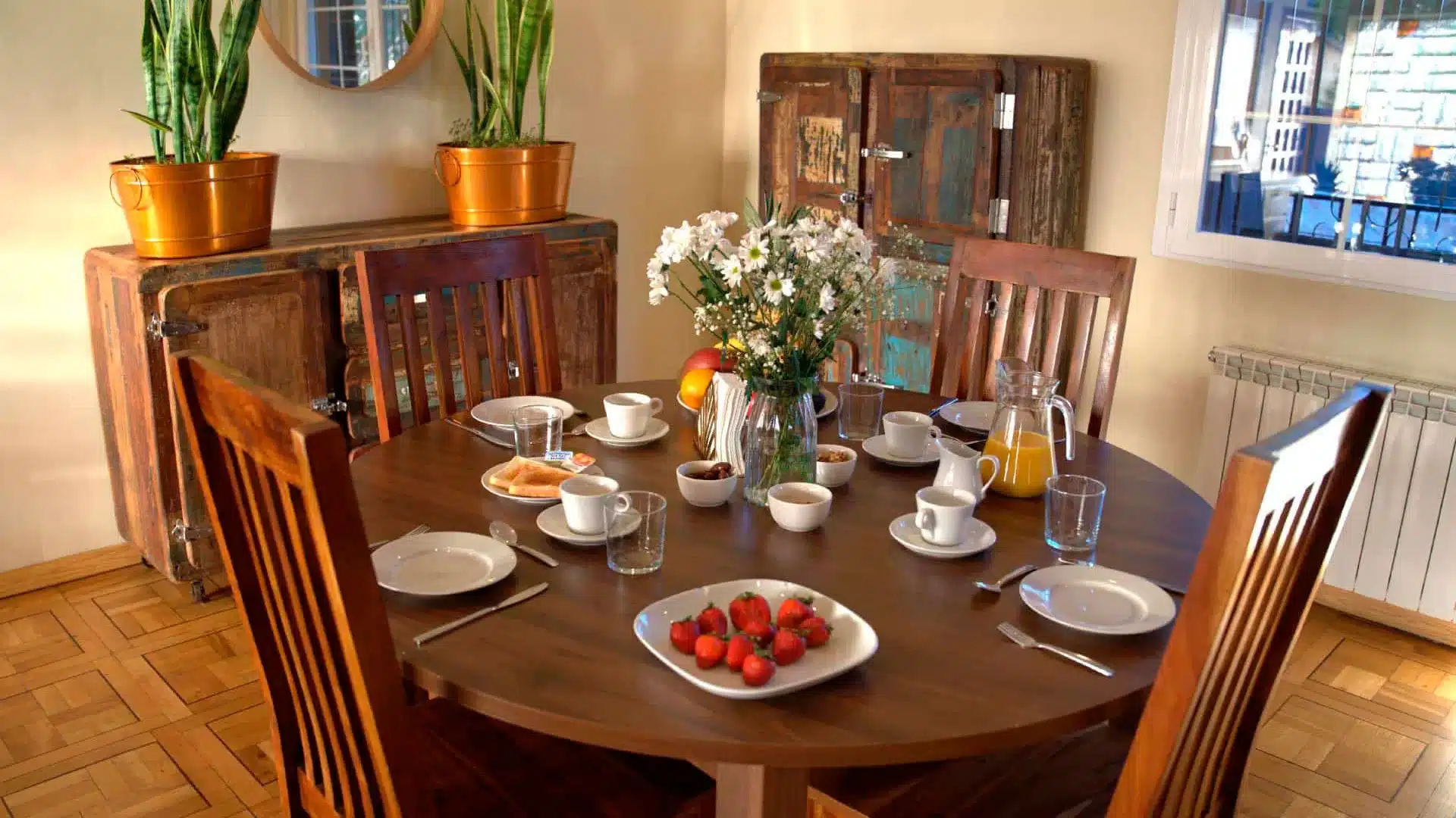 Comedor del Centro Árbor: alimentación saludable y convivencia terapéutica Mesa redonda preparada para el desayuno con frutas, zumo y café en el comedor del Centro Árbor en Soto del Real, Madrid.