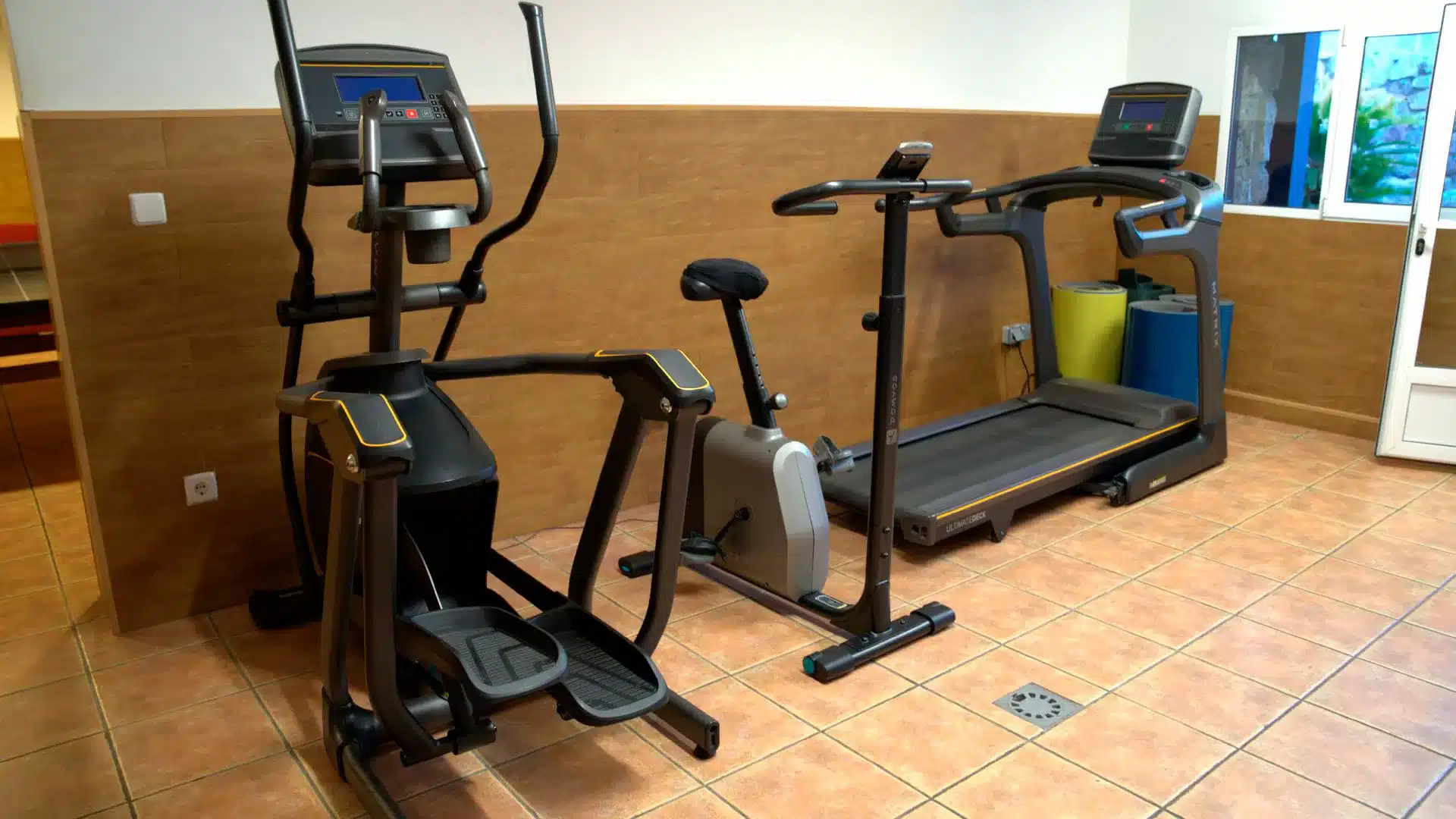 Gimnasio terapéutico en el Centro de Adicciones Árbor Sala de gimnasio con cinta de correr, bicicleta estática y elíptica en el Centro de Adicciones Árbor.